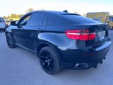 the back of a black bmw suv parked in a parking lot