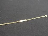 gros plan d'un bracelet en or sur une surface noire