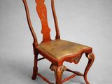 a wooden chair with a leather seat on a grey background