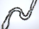 a close up of a strand of pearls on a white surface