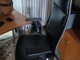 a black office chair sitting in front of a computer desk