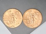 two gold coins sitting on top of a table next to each other