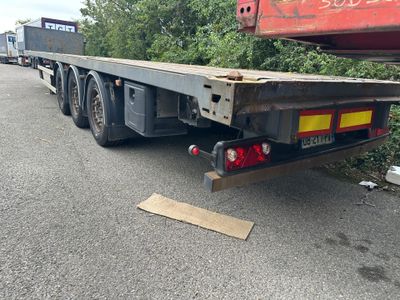 un camion à plateau garé sur le bord de la route