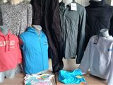 many clothing items on display on a table in a room