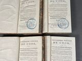 quatre vieux livres portant des timbres, posés sur une table