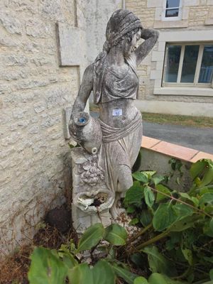une statue représentant une femme tenant un bébé dans un jardin