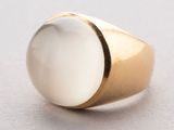 a close up of a gold ring with a white stone on it