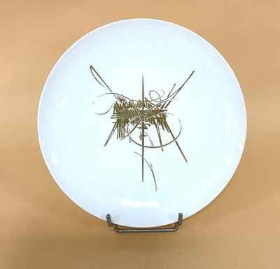 une assiette blanche posée sur une table, avec un peu d'herbe dessus