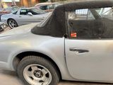 a silver car with a black top parked in a parking lot