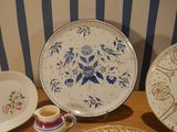 many plates and cups on a table with a striped wall