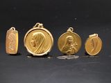 trois médailles d'or et une pièce de monnaie posées sur un fond noir