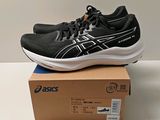 des chaussures de course Asics posées sur une boîte, sur une surface blanche