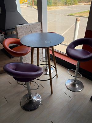 three chairs and a table in a room with a large window