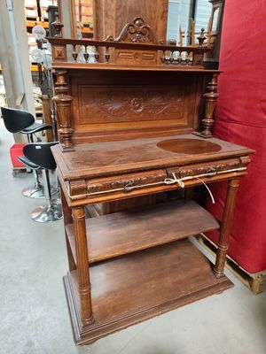 an old wooden desk with a red chair in the background
