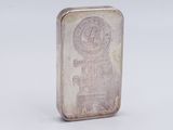 an old silver bar with a small logo on it