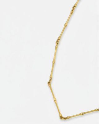 un collier en or composé d'une longue chaîne fabriquée à partir de tiges de bambou