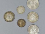 six different types of coins on a table with a white background