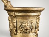 an image of a gold mortar with a bottle of wine in it