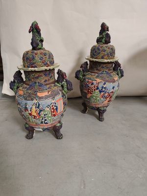 une paire de vases asiatiques ornés de motifs colorés, posés sur une table
