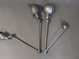 four metal spoons sitting on top of a table