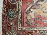 a close up of a very old rug on a white surface
