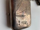 a small silver box with a chain attached to it