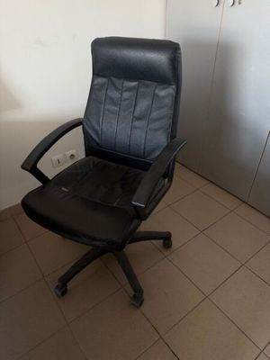une chaise de bureau noire dans un coin de la pièce