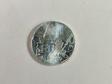 une pièce d'argent sur laquelle figure l'image d'un homme