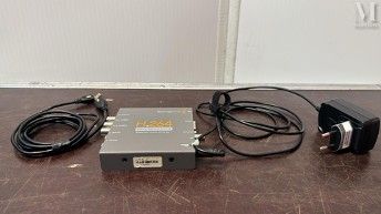 un appareil électronique posé sur une table, à côté d'un chargeur