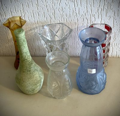 trois vases en verre posés sur une table l'un à côté de l'autre