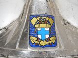 a metal bell with a blue and white emblem on it