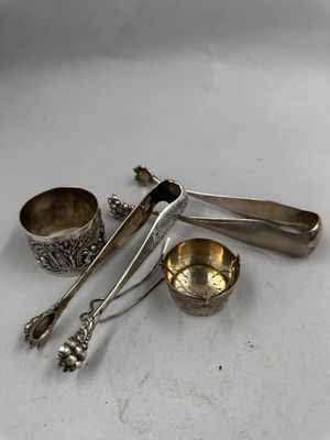 trois cuillères en argent et deux tasses en argent posées sur un plat blanc