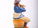 a figurine of a man with a baseball bat sitting on top of a ball