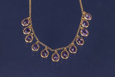 un collier en or orné d'améthystes sur fond noir