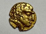 a close up of a gold coin with a man ' s face on it