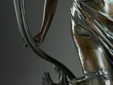 bronze statue of a woman holding a staff and a flower