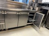 une grande cuisine en inox équipée d'un évier et d'un réfrigérateur