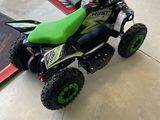 une photo d'une moto tout-terrain verte et noire dans un garage