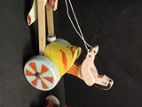 a wooden toy horse pulling a cart with a man on it