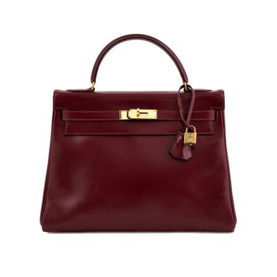 a burgundy leather handbag with gold hardware