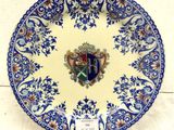 a blue and white plate with a coat of arms on it