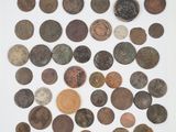 a pile of old coins sitting on top of a white surface
