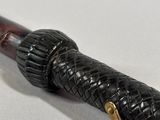 a close up of a pen on a white surface with a gold handle