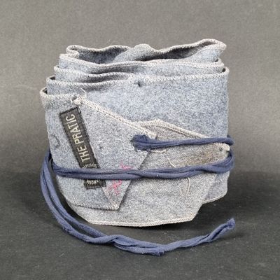 grey felt bag with blue string and a tag on it