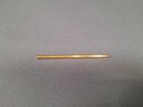 a gold colored pencil sitting on top of a gray surface