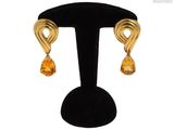 gros plan d'une paire de boucles d'oreilles sur un support