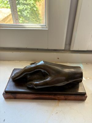 a statue of a hand resting on a wooden block