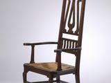 une chaise ancienne en bois, avec un dossier et une assise sculptés, sur fond blanc