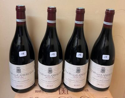 four bottles of red wine sitting on top of a wooden box