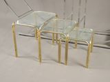 three glass and brass nesting tables on a white background